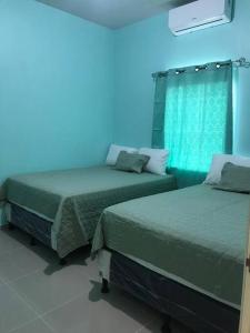 duas camas num quarto com fundo azul em Tu mejor opción em Juticalpa