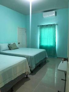 um quarto com duas camas e uma luz azul em Tu mejor opción em Juticalpa