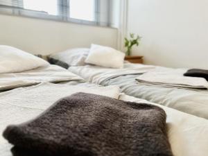 2 weiße Betten nebeneinander in einem Zimmer in der Unterkunft DOMspitzen-BLICK, cooles 2 Zimmer Apt mit Küche und Smart-TV in Köln