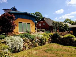 Casa amarilla y azul con pared de piedra en Feriengrundstück direkt am See, en Dabel