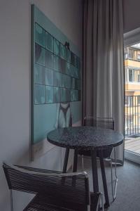 a table and chairs in a room with a window at Resume Apartments, Swimmer Corner No 2 by URBAN RENT in Kaunas