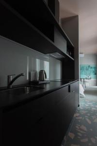 a kitchen with a sink and a black counter top at Resume Apartments, Swimmer Corner No 2 by URBAN RENT in Kaunas