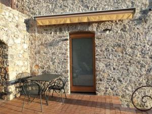 um pátio com uma mesa e cadeiras em frente a um edifício de pedra em Schönes Appartement in Tortorella mit Terrasse und Garten em Tortorella