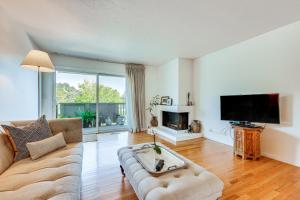 a living room with a couch and a tv at Beautiful Bay Area Condo with Mount Tamalpais Views in Green Brae