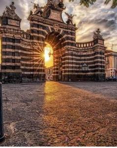 un gran edificio con la puesta de sol detrás de él en Sicily house, en Catania
