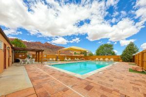 a swimming pool with tables and chairs in a backyard at Rim Village L3 in Moab