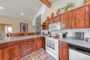 cocina con armarios de madera y horno de fogón blanco en Rim Village L3 en Moab