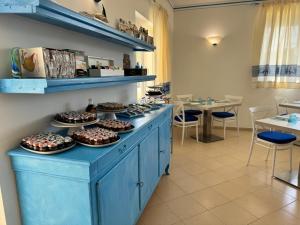 a counter with cupcakes on it in a restaurant at Garden Hotel Alghero in Fertilia