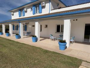 a house with blue potted plants on a patio at Garden Hotel Alghero in Fertilia