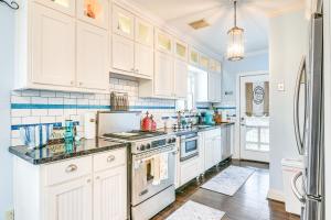 a kitchen with white cabinets and a stove top oven at Pet-Friendly Galveston Bungalow, half Mi to Beach! in Galveston