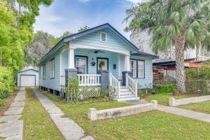 a blue house with a porch and a palm tree at Pet-Friendly Galveston Bungalow, half Mi to Beach! in Galveston