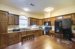 una cocina con armarios de madera y una gran mesa de madera. en Homey Greenwood Getaway with Patio and Backyard, en Greenwood