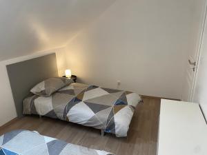 a bedroom with a bed with a geometric comforter at Maison de ville des Bernardines in Orgelet