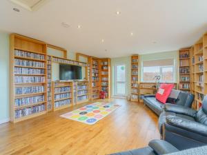 a living room with a couch and book shelves at 5 Bed in Mold 79345 in Llanferres