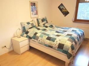 a bedroom with a bed with a quilt on it at Wohnung in Bad Ditzenbach mit Eigenem Garten in Bad Ditzenbach