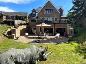 a statue of a rhino in front of a house at Stansted Airport Stay, Parking and Luxury Suite in Birchanger