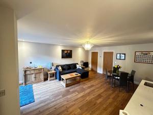 ein Wohnzimmer mit einem Sofa und einem Tisch in der Unterkunft Stansted Airport Stay, Parking and Luxury Suite in Birchanger