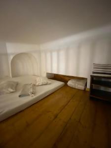 a bedroom with a white bed and a wooden floor at Museum Apartments in Lviv