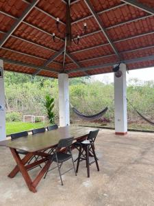 a wooden table and chairs under a roof at Trailer House in Vara Blanca