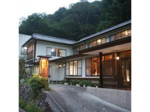 uma casa grande com uma estrada em frente em Shimaonsen AYAMEYA Ryokan - Vacation STAY 20622v em Shima