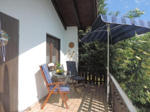 un patio con 2 sillas y una sombrilla en Ferienhaus Schlossblick mit Teilseeblick en Waldeck