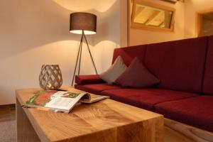 uma sala de estar com um sofá vermelho e uma mesa de centro em Luxuschalet im FORSTGUT - Raum für wertvolle Zeit em Regen