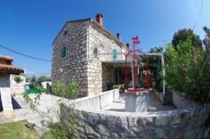 a stone building with a stone wall in front of it at Ferienhaus in Rakalj mit Grill, Garten und Terrasse in Rakalj