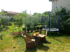 een tuin met 2 stoelen en een tafel en een schommel bij Ferienhaus in Rakalj mit Grill, Garten und Terrasse in Rakalj