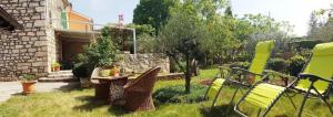 a garden with chairs and a table in the grass at Ferienhaus in Rakalj mit Grill, Garten und Terrasse in Rakalj