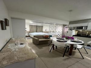 Belém NovoSTUDIO 201 | WIFI 600MB | RESIDENCIAL JC, um lugar para ficar.的厨房和客厅，配有一张床和一张桌子