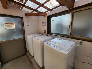 una lavanderia con tre lavatrici e finestre di Naraha Fukujusou - Vacation STAY 89024v a Naraha