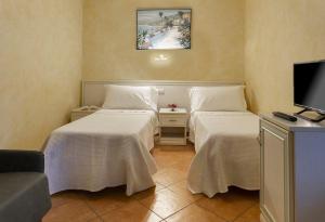 a hotel room with two beds and a tv at Appartement in Scandiano mit Privatem Parkplatz - b56491 in Scandiano