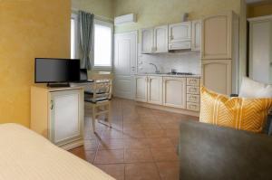 a kitchen with white cabinets and a desk with a television at Appartement in Scandiano mit Privatem Parkplatz - b56491 in Scandiano