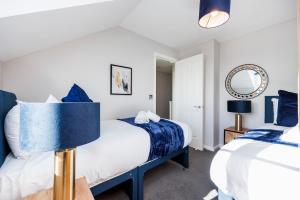 una camera con due letti e uno specchio di 4 Bed Townhouse in Uxbridge Ideal For Families or Contractors a Hillingdon