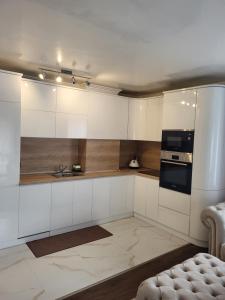 a kitchen with white cabinets and a stove top oven at Luxury apartment in Teteven