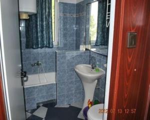 a blue tiled bathroom with a sink and a toilet at Ferienwohnung in Fonyd mit Garten - a88015 in Fonyód