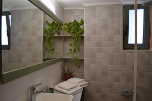 ein Badezimmer mit einem Waschbecken, einem WC und einem Spiegel in der Unterkunft Loupino Family House in Stoupa