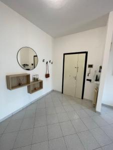 um quarto branco com um espelho e uma porta em La casa di Ciccio em Limite