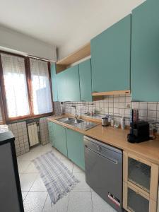 uma cozinha com armários azuis e um lavatório em La casa di Ciccio em Limite