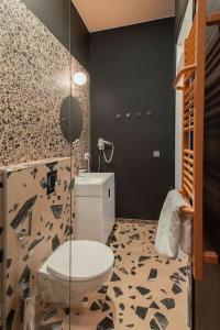 een badkamer met een toilet en een glazen douche bij Resume Apartments, Reporter Corner No 5 by URBAN RENT in Kaunas
