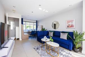 a living room with a blue couch and a table at 4 Bed Townhouse in Uxbridge Ideal For Families or Contractors in Hillingdon