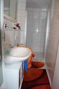 een witte badkamer met een wastafel en een douche bij Wunderschönes Ferienhaus in Zainingen mit Eigener Terrasse in Zainingen