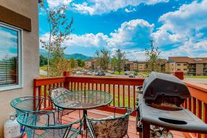 a grill on a balcony with a table and chairs at Cascades Townhomes by Steamboat Resorts in Steamboat Springs