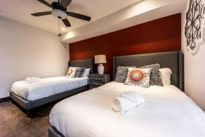 1 dormitorio con 2 camas y ventilador de techo en 2 Stylish Gulch Town Homes - Rooftop Hot Tub - Sleeps 24, en Nashville