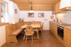 a kitchen with a wooden table and chairs in it at Wohnung in Oberau in Oberau