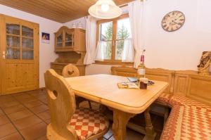 a kitchen with a wooden table and a clock on the wall at Wohnung in Oberau in Oberau