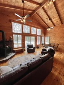 a living room with a couch and a tv in a log cabin at THE RIVER HOUSE LIMIT 6 home 