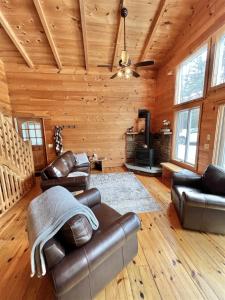uma sala de estar com mobiliário de couro num chalé de madeira em THE RIVER HOUSE LIMIT 6 home 