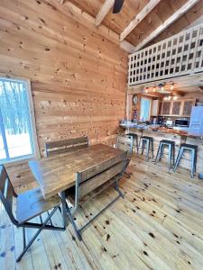 uma sala de jantar com paredes de madeira e mesas e bancos de madeira em THE RIVER HOUSE LIMIT 6 home 