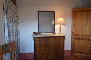 einen Spiegel auf der Kommode mit einer Lampe in der Unterkunft Studio für 4 Personen ca 60 qm in Monteriggioni, Toskana Chianti in Monteriggioni